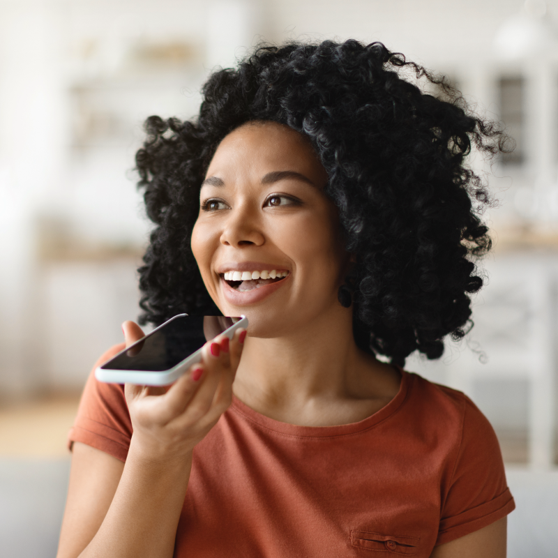 Dark skinned women with curly hair talking through a phone